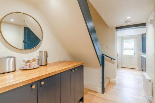 a kitchen with a counter and a mirror at Vine Cottage, Charlbury in Charlbury