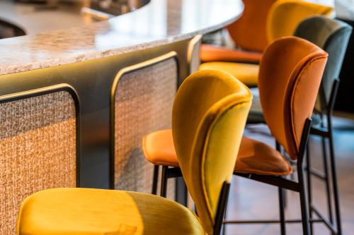 a row of yellow chairs at a table at Hotel D Bulle - La Gruyère in Bulle