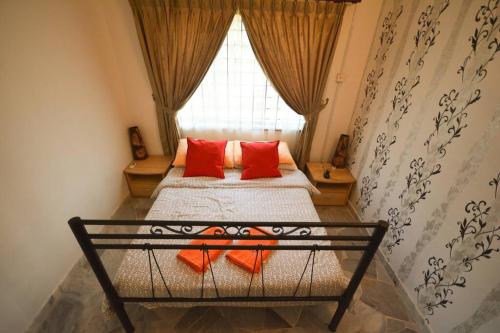 a bedroom with a bed with red pillows and a window at Homestay PD Villa 969 with Private Pool in Port Dickson