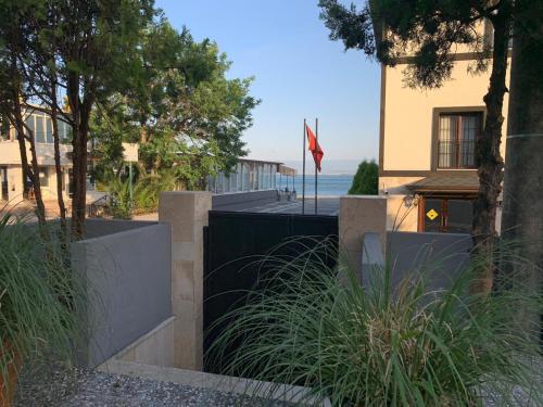 uma casa com uma cerca preta e uma bandeira em akcayzeytin otel em Akçay