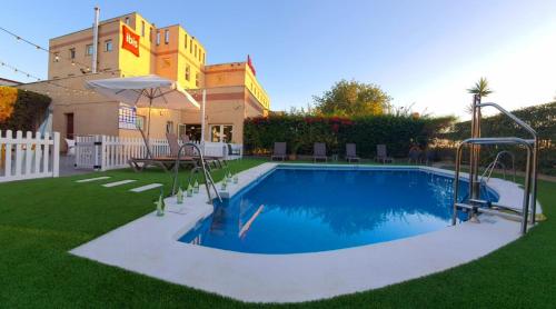 a swimming pool in the middle of a yard at Ibis Jerez De La Frontera Cadiz in Jerez de la Frontera