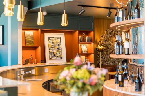 a bar in a restaurant with flowers on a counter at Hotel D Bulle - La Gruyère in Bulle