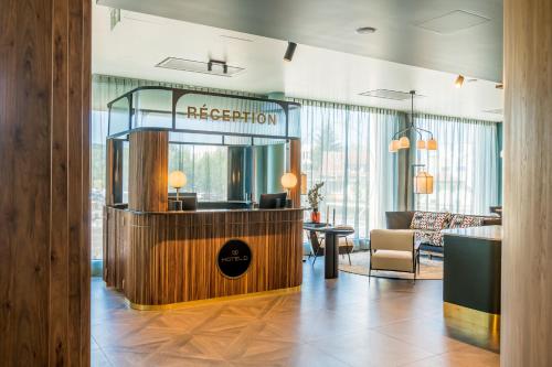 a reception area in a hotel lobby with a mirror at Hotel D Bulle - La Gruyère in Bulle