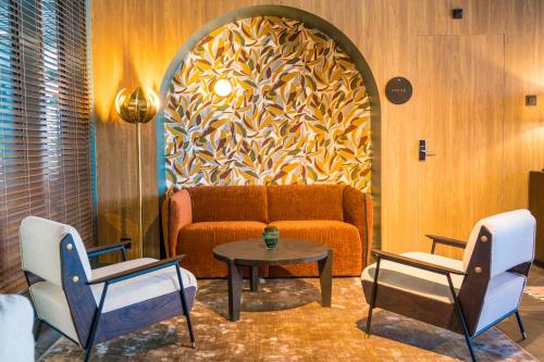 a living room with a couch and two chairs and a table at Hotel D Bulle - La Gruyère in Bulle