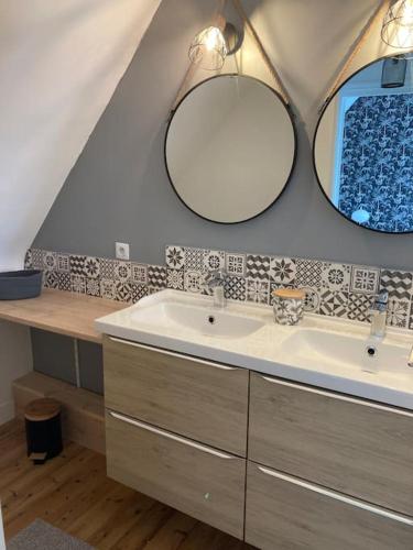 une salle de bain avec un lavabo et deux miroirs dans l'établissement La marinière, à Locquirec