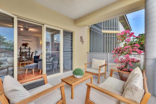 a patio with chairs and tables on a balcony at Parap Markets Condo 2BR 2BA (ens) in Paraparap