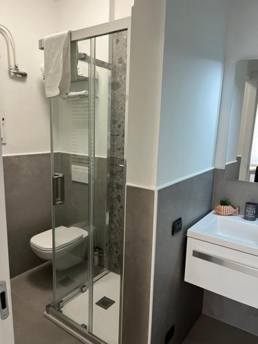 uma casa de banho com um chuveiro, um WC e um lavatório. em Apartment Verdi BARDOLINO em Bardolino
