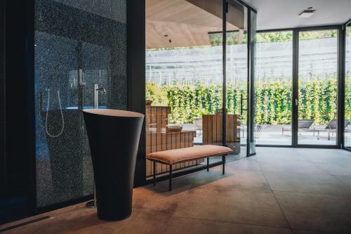 a bathroom with a bench and a shower in a room at Klein Fein Hotel Anderlahn in Parcines