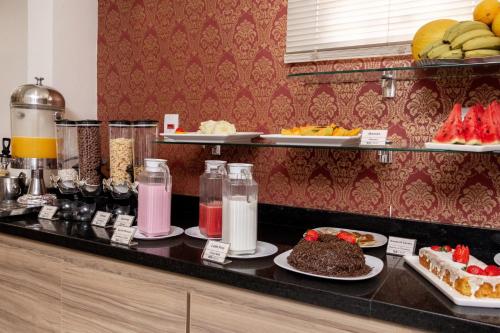 a buffet with plates of food on a counter at Astor Hotel in Bauru