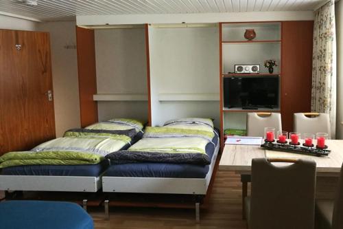 Habitación con 3 camas y mesa con velas rojas en B4 Schwarzwald-Fewo an der Alb, en Menzenschwand