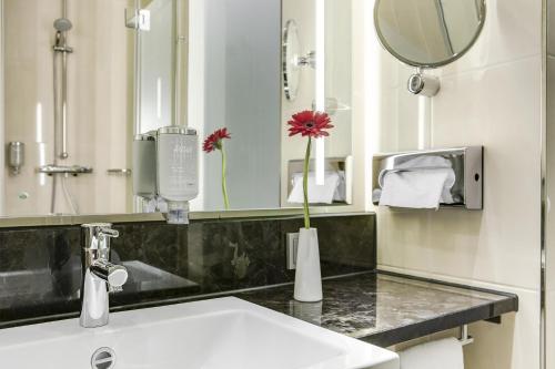 bagno con lavandino e specchio di IntercityHotel Ingolstadt a Ingolstadt