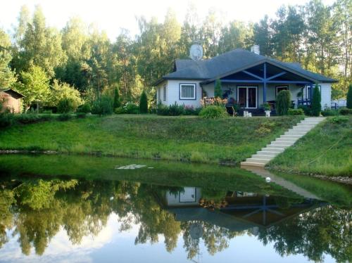 a house with its reflection in the water at Māja pie jūras in Batciems
