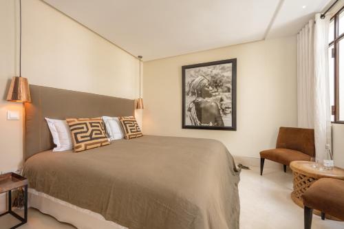 a bedroom with a large bed and a chair at Riad Dar Labzar in Marrakesh