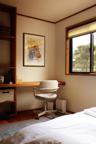 a bedroom with a bed and a desk and a chair at Akizuki Niwa (Garden) House in Asakura