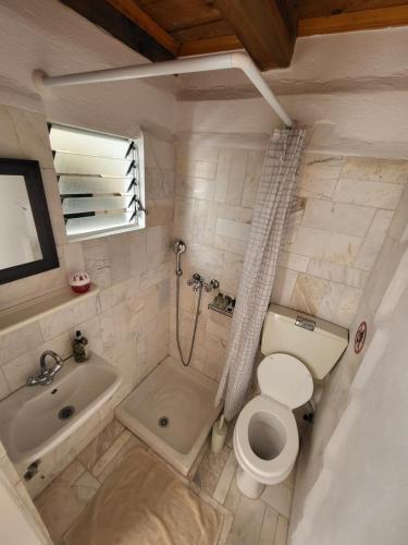 a bathroom with a toilet and a tub and a sink at Atrium house in Rethymno