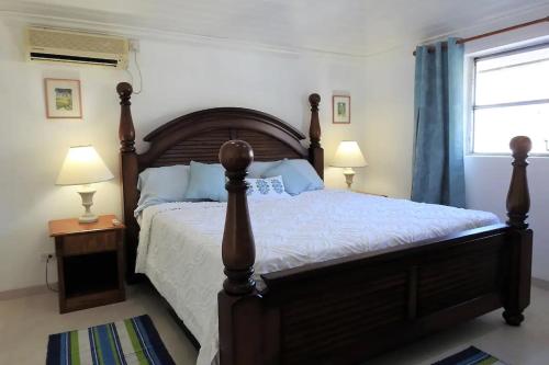 a bedroom with a bed and two lamps and a window at Zenbreak Freshwater Beachfront 6 in Saint Michael