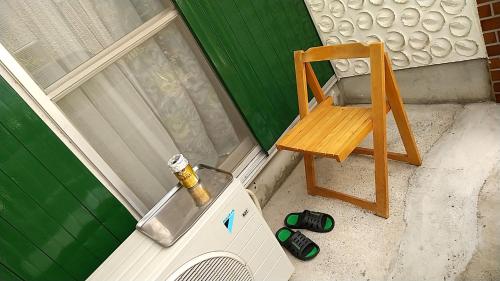 uma cadeira de madeira ao lado de uma máquina de lavar roupa em MINPAKU-P 民泊p em Izumi-Sano