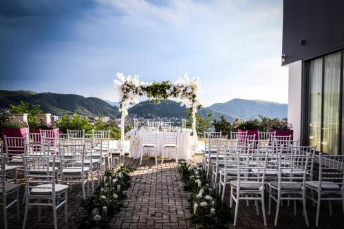 a wedding aisle with white chairs and an altar at 7even weddings & events in Štip