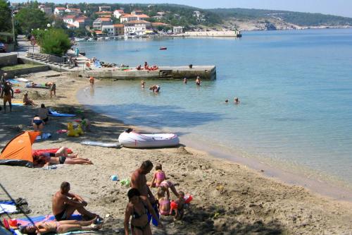 a group of people on a beach in the water at Apartments with parking space Silo, Krk - 18758 in Šilo