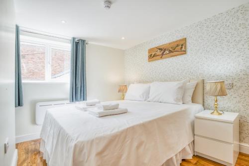 a bedroom with a large white bed with a window at Superb City Center 2 Bed Apartment Free Wifi in Lincoln