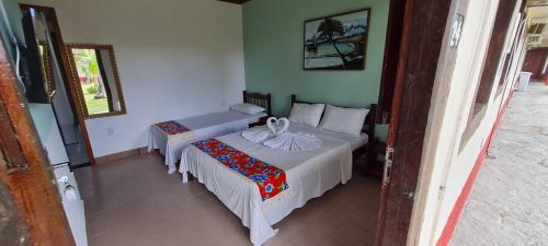 A bed or beds in a room at Pousada Morada dos Coqueiros