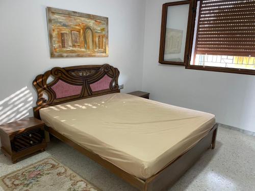 Schlafzimmer mit einem Bett, einem Spiegel und einem Fenster in der Unterkunft Zahra 1 in Houmt Souk