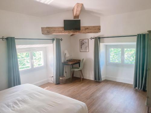 um quarto com uma cama, uma secretária e janelas em Hotel Savel em Ruoms