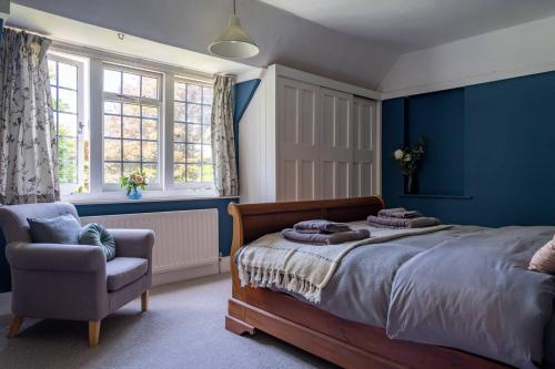 Schlafzimmer mit blauen Wänden, einem Bett und einem Stuhl in der Unterkunft Anoush in Everton