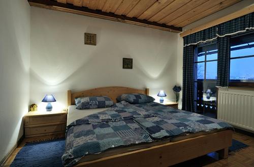 a bedroom with a bed with two night stands and a window at Apartments Cesar in Bohinj