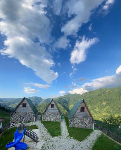 a group of cottages with mountains in the background at Elabay Dağ Evleri in Çamlıhemşin