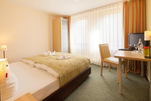 a hotel room with a bed and a desk and a computer at Altes Forsthaus Braunlage in Braunlage