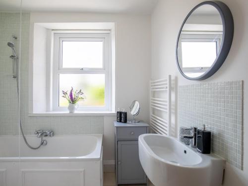 a white bathroom with a sink and a mirror at Kimkeri in Bourton on the Water