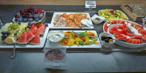 a buffet of different types of food on a table at Hotel PrimaVera parco in Fürth