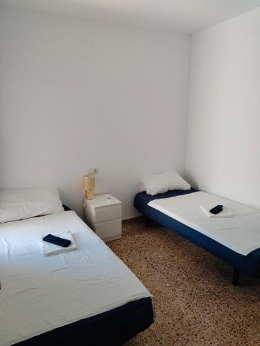 two beds in a room with white walls at City Centre apartments in Denia