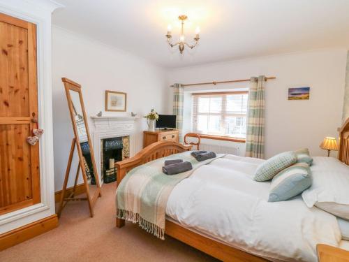 a bedroom with a bed and a fireplace at Morannedd in Llanfairpwllgwyngyll