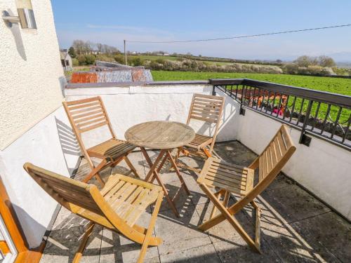 a table and four chairs sitting on a balcony at Morannedd in Llanfairpwllgwyngyll