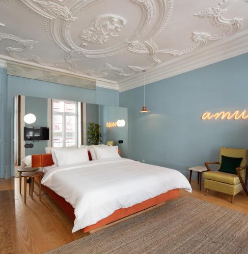a bedroom with a large bed with blue walls and a ceiling at Almadina Smart Luxury in Porto