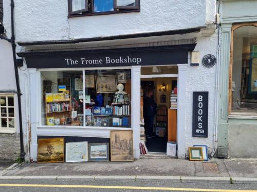 a store front of a corner bookshop with a sign at The Undercoft luxury private studio at The Old Church House central Frome in Frome