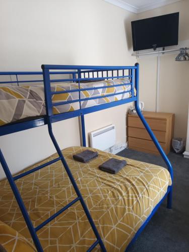 two bunk beds in a room with a television at Strides Hotel in Blackpool