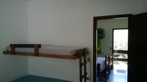 Zimmer mit 2 Etagenbetten an der Wand in der Unterkunft Cond Apartamentos Chalés San Marino in Ubatuba