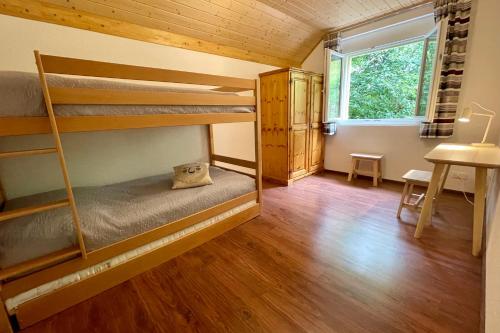 Haus Heimetli - CharmingStay في فلمسربرغ: غرفة نوم مع أسرة بطابقين في منزل صغير