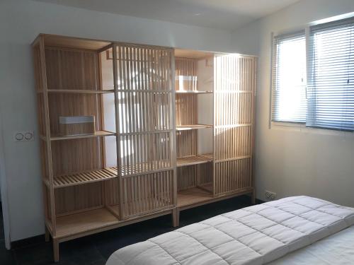 sypialnia z drewnianymi półkami na książki i łóżkiem w obiekcie Maisonnette indépendante avec jardin/patio w mieście Nîmes