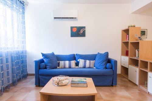 a blue couch in a living room with a table at AGIAZI Poros Summer House in Galatas
