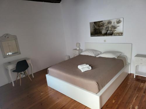 ein Schlafzimmer mit einem Bett, einem Tisch und einem Stuhl in der Unterkunft Atrium house in Rethymno