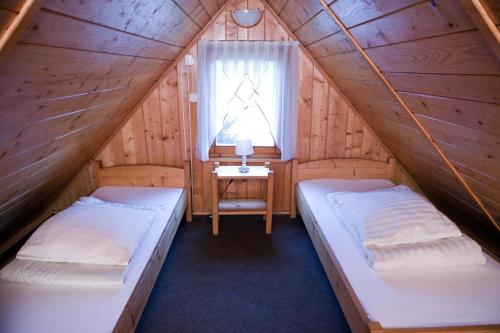 two beds in a room with a window at Domki z jacuzzi Pasja I in Mizerna
