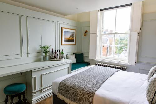a bedroom with a bed and a desk and a window at The Bull & Last in London