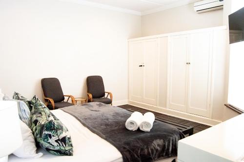 1 dormitorio con 1 cama y 2 sillas en Thistle Hotel, en Pietermaritzburg