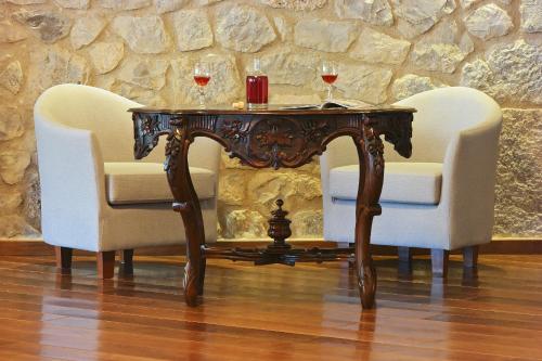 a table with two glasses of wine and two chairs at Ellinon Thea Arachova in Arachova