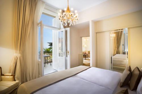 sypialnia z białym łóżkiem i żyrandolem w obiekcie Villa Amalia - Liburnia w mieście Opatija