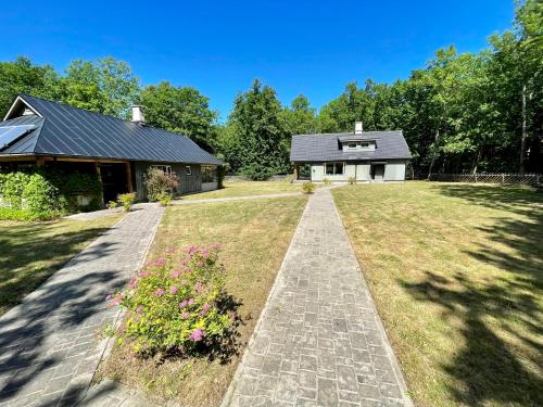 a house with a brick pathway leading to a house at Lehtla Puhkekompleks in Austla